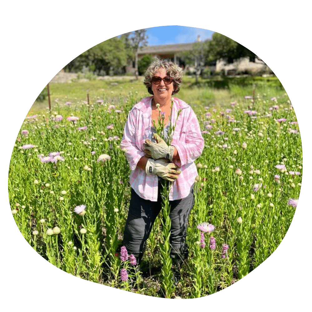 Ginger webb herbalist standing in meadow of flowers